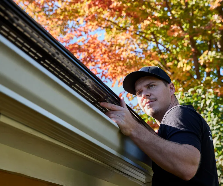 Installer inspecting the roofline before gutter work